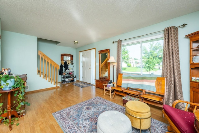 9102 NW Windsor Dr, Johnston, IA 50131 - living area with stairway, wood finished floors, and a textured ceiling