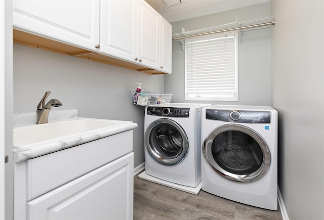 5526 Kensington Cir, Johnston, IA 50131 - washroom with cabinet space, independent washer and dryer, and light wood-type flooring