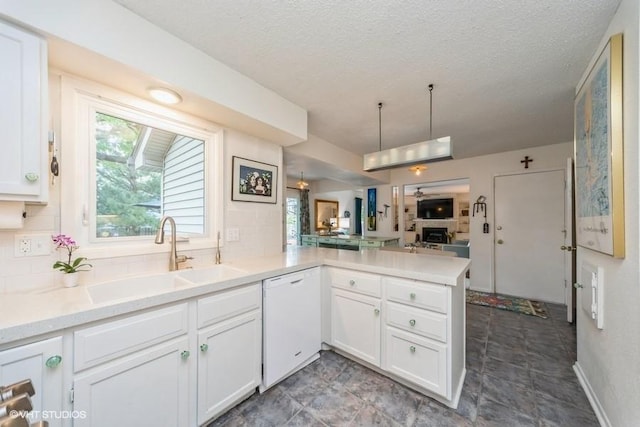 4505 75th St, Urbandale, IA 50322 - kitchen with white dishwasher, a peninsula, open floor plan, white cabinets, and a textured ceiling