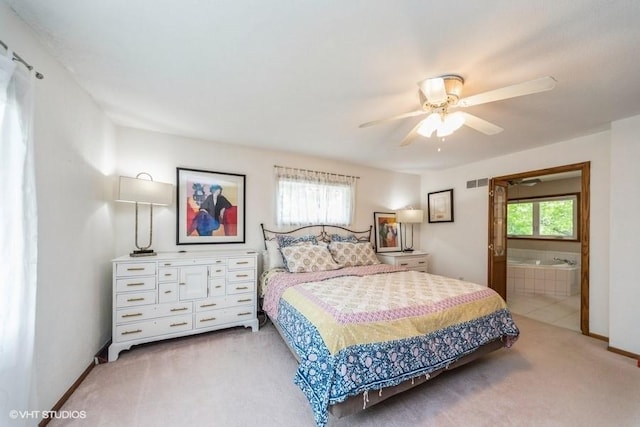 4505 75th St, Urbandale, IA 50322 - carpeted bedroom with multiple windows, ensuite bathroom, and a ceiling fan