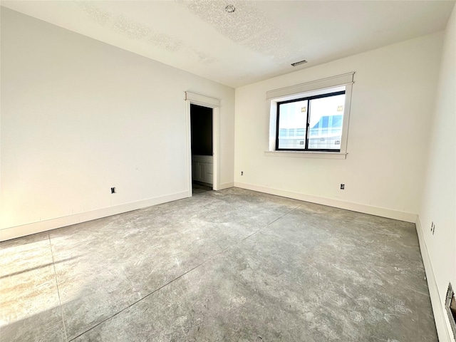 880 Harrington Way, Waukee, IA 50263 - spare room featuring concrete floors and a textured ceiling