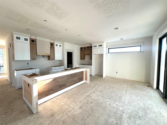 880 Harrington Way, Waukee, IA 50263 - kitchen featuring a textured ceiling, glass insert cabinets, and white cabinets