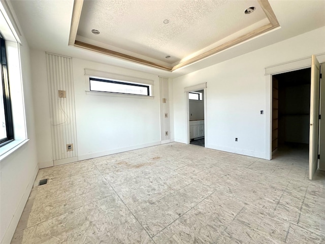 880 Harrington Way, Waukee, IA 50263 - unfurnished bedroom with a raised ceiling, a textured ceiling, and ensuite bath