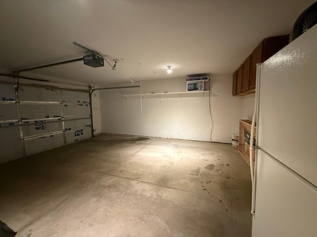 244 4th Ave W, Grinnell, IA 50112 - garage with freestanding refrigerator and a garage door opener
