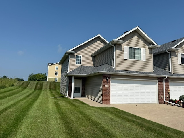 244 4th Ave W, Grinnell, IA 50112 - view of front of house with brick siding, a garage, driveway, and a front yard