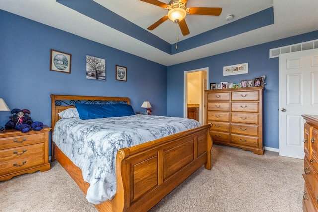 1870 SE Oxford Dr, Waukee, IA 50263 - bedroom with a raised ceiling, light carpet, a ceiling fan, and connected bathroom