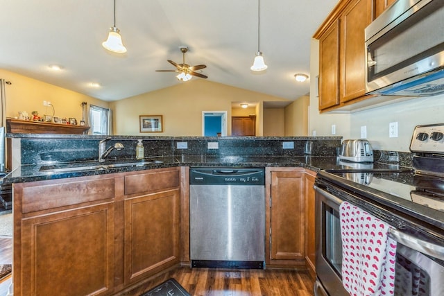 1870 SE Oxford Dr, Waukee, IA 50263 - kitchen with stainless steel appliances, vaulted ceiling, ceiling fan, dark wood-style floors, and brown cabinets