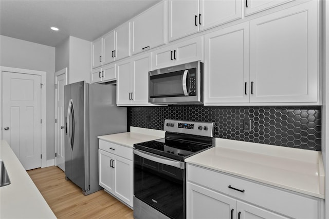 1375 SE Parkview Crossing Dr, Waukee, IA 50263 - kitchen with stainless steel appliances, white cabinets, light countertops, light wood-type flooring, and recessed lighting