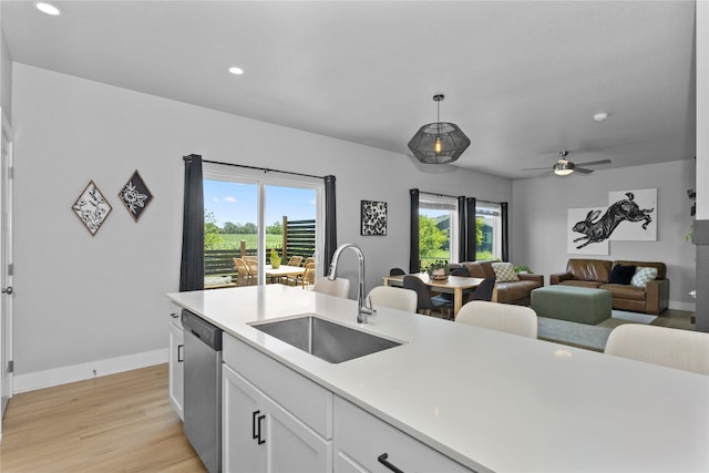 1375 SE Parkview Crossing Dr, Waukee, IA 50263 - kitchen featuring stainless steel dishwasher, light countertops, plenty of natural light, light wood-style flooring, and recessed lighting