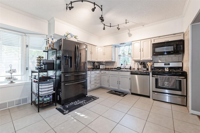 3504 56th St, Des Moines, IA 50310 - kitchen with dark countertops, appliances with stainless steel finishes, crown molding, tasteful backsplash, and light tile patterned floors