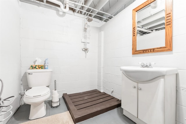 3504 56th St, Des Moines, IA 50310 - bathroom with vanity, a tile shower, and concrete block wall