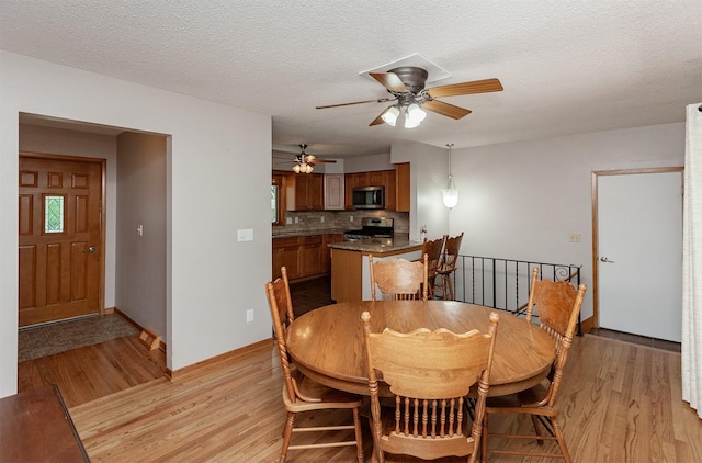 2726 Lakeland Dr, Urbandale, IA 50322 - dining area featuring light wood finished floors, a ceiling fan, and a textured ceiling