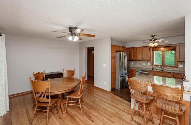2726 Lakeland Dr, Urbandale, IA 50322 - dining space featuring a ceiling fan, light wood-type flooring, and a textured ceiling