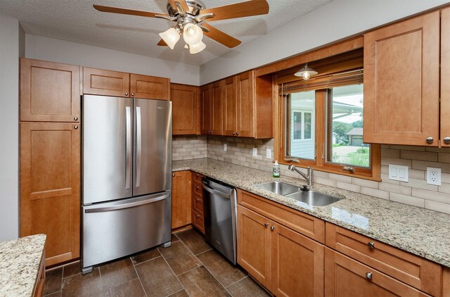 2726 Lakeland Dr, Urbandale, IA 50322 - kitchen with stainless steel appliances, tasteful backsplash, ceiling fan, light stone counters, and a textured ceiling