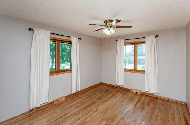 2726 Lakeland Dr, Urbandale, IA 50322 - unfurnished room with light wood finished floors, ceiling fan, and a textured ceiling