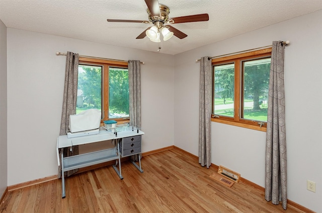 2726 Lakeland Dr, Urbandale, IA 50322 - office area featuring light wood finished floors, ceiling fan, and a textured ceiling