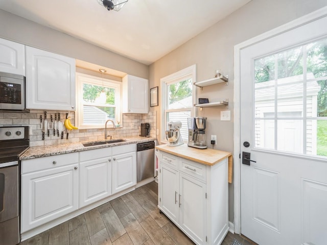 3934 Lincoln Place Dr, Des Moines, IA 50312 - kitchen with appliances with stainless steel finishes, plenty of natural light, light wood-type flooring, and decorative backsplash