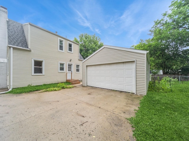3934 Lincoln Place Dr, Des Moines, IA 50312 - rear view of house featuring a garage, a shingled roof, an outdoor structure, and a chimney