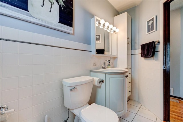 5613 College Ave, Des Moines, IA 50310 - bathroom featuring tile walls, vanity, tile patterned floors, and a wainscoted wall