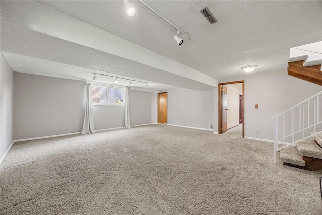 7005 Surrey Dr NE, Cedar Rapids, IA 52402 - carpeted empty room featuring track lighting, stairway, and a textured ceiling