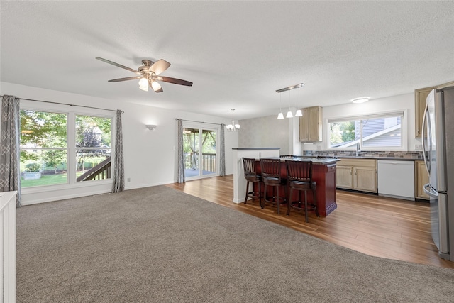 7005 Surrey Dr NE, Cedar Rapids, IA 52402 - kitchen with freestanding refrigerator, open floor plan, a ceiling fan, healthy amount of natural light, and a textured ceiling