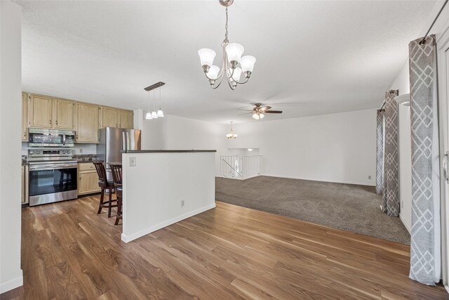 7005 Surrey Dr NE, Cedar Rapids, IA 52402 - kitchen with a chandelier, stainless steel appliances, a ceiling fan, light brown cabinets, and dark wood finished floors