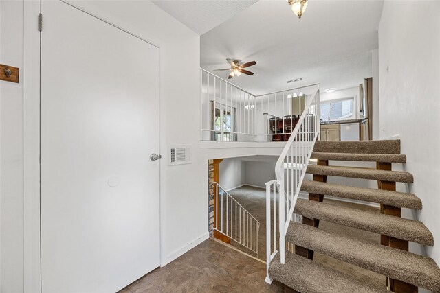 7005 Surrey Dr NE, Cedar Rapids, IA 52402 - staircase with ceiling fan and concrete floors