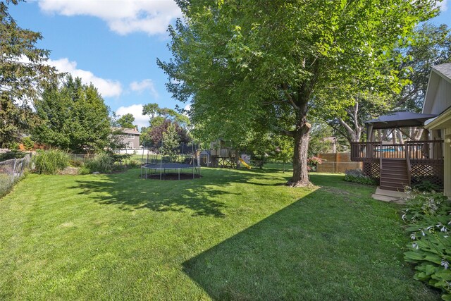 7005 Surrey Dr NE, Cedar Rapids, IA 52402 - fenced backyard with a trampoline, stairs, a playground, and a deck