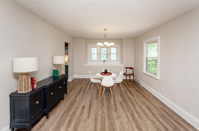 910 30th St, Des Moines, IA 50312 - dining space featuring light wood finished floors and a chandelier