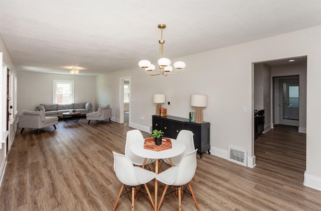910 30th St, Des Moines, IA 50312 - dining space featuring a chandelier and wood finished floors