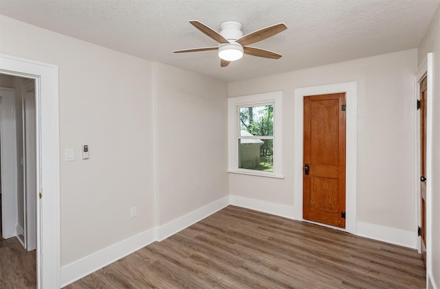 910 30th St, Des Moines, IA 50312 - spare room with wood finished floors, a ceiling fan, and a textured ceiling