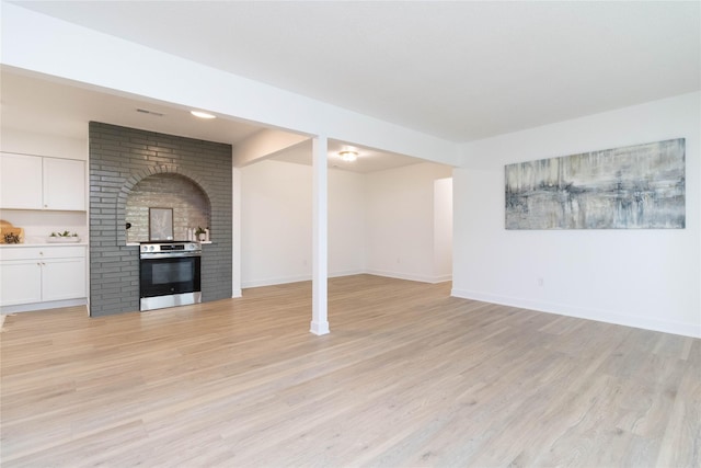 1410 20th St Unit 20, West Des Moines, IA 50265 - unfurnished living room featuring light wood-type flooring and a fireplace