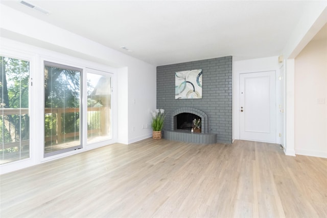 1410 20th St Unit 20, West Des Moines, IA 50265 - unfurnished living room with light wood-style floors and a brick fireplace