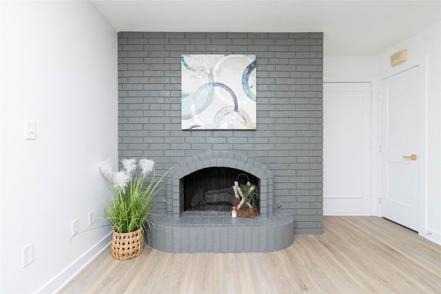 1410 20th St Unit 20, West Des Moines, IA 50265 - unfurnished living room with wood finished floors and a brick fireplace