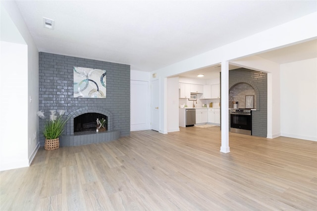 1410 20th St Unit 20, West Des Moines, IA 50265 - unfurnished living room with a fireplace and light wood-style floors