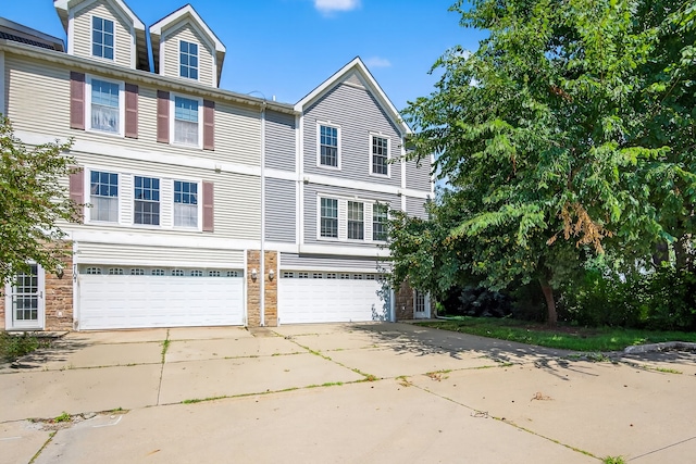 8302 Westown Pkwy Unit 7106, West Des Moines, IA 50266 - view of front of property featuring concrete driveway, an attached garage, and stone siding