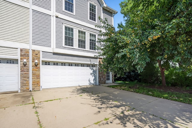 8302 Westown Pkwy Unit 7106, West Des Moines, IA 50266 - view of front facade with stone siding, concrete driveway, and an attached garage