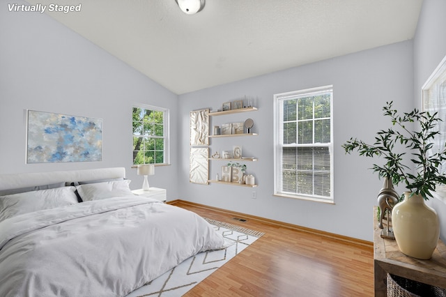 8302 Westown Pkwy Unit 7106, West Des Moines, IA 50266 - bedroom featuring wood finished floors and vaulted ceiling
