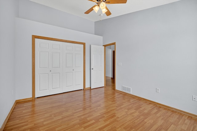 8302 Westown Pkwy Unit 7106, West Des Moines, IA 50266 - unfurnished bedroom with light wood finished floors, a closet, a ceiling fan, and a high ceiling