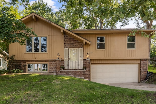 3312 Kinsey Ave, Des Moines, IA 50317 - raised ranch with a front lawn, a garage, brick siding, and driveway