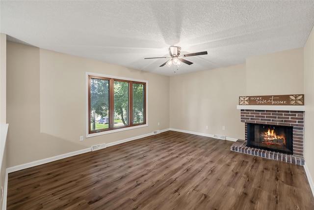 3312 Kinsey Ave, Des Moines, IA 50317 - unfurnished living room featuring wood finished floors, a ceiling fan, a brick fireplace, and a textured ceiling