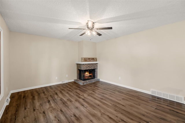 3312 Kinsey Ave, Des Moines, IA 50317 - unfurnished living room with ceiling fan, wood finished floors, a fireplace, and a textured ceiling