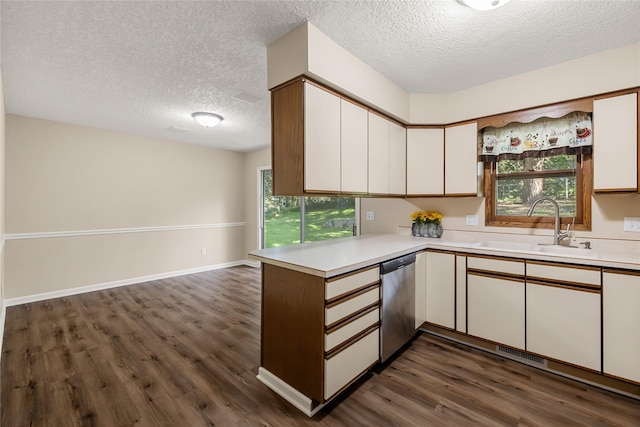 3312 Kinsey Ave, Des Moines, IA 50317 - kitchen featuring light countertops, dark wood-style flooring, a textured ceiling, a peninsula, and white cabinets
