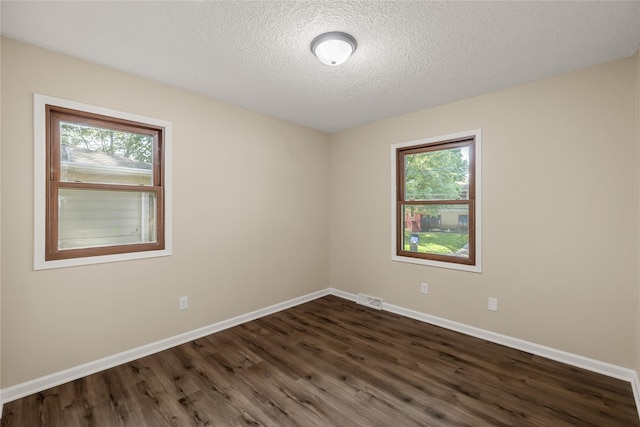 3312 Kinsey Ave, Des Moines, IA 50317 - unfurnished room with dark wood-style floors, healthy amount of natural light, and a textured ceiling