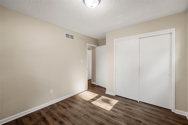 3312 Kinsey Ave, Des Moines, IA 50317 - unfurnished bedroom with wood finished floors, a closet, and a textured ceiling