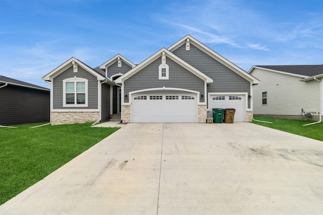 220 11th Ct NW, Bondurant, IA 50035 - craftsman-style house with stone siding, a garage, a front yard, and concrete driveway