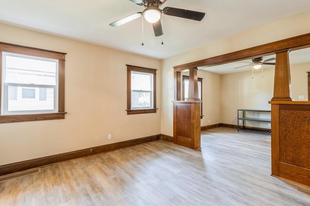 1141 Douglas Ave, Des Moines, IA 50313 - unfurnished room featuring a ceiling fan, wood finished floors, and decorative columns