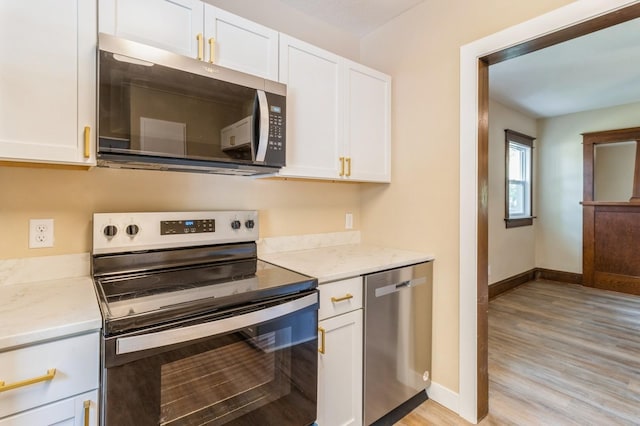1141 Douglas Ave, Des Moines, IA 50313 - kitchen with appliances with stainless steel finishes, white cabinetry, light wood-style floors, and light stone counters