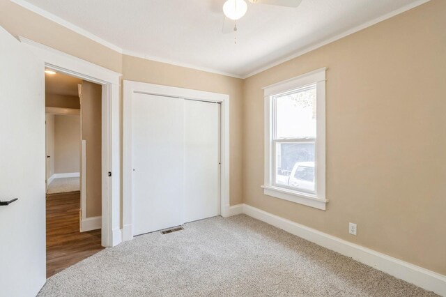 1141 Douglas Ave, Des Moines, IA 50313 - unfurnished bedroom featuring ornamental molding, a closet, carpet flooring, and a ceiling fan