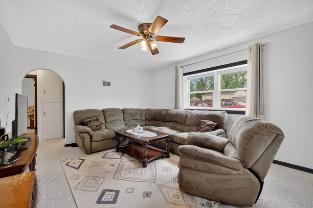 3605 53rd St, Des Moines, IA 50310 - living room featuring arched walkways, light carpet, ceiling fan, and a textured ceiling